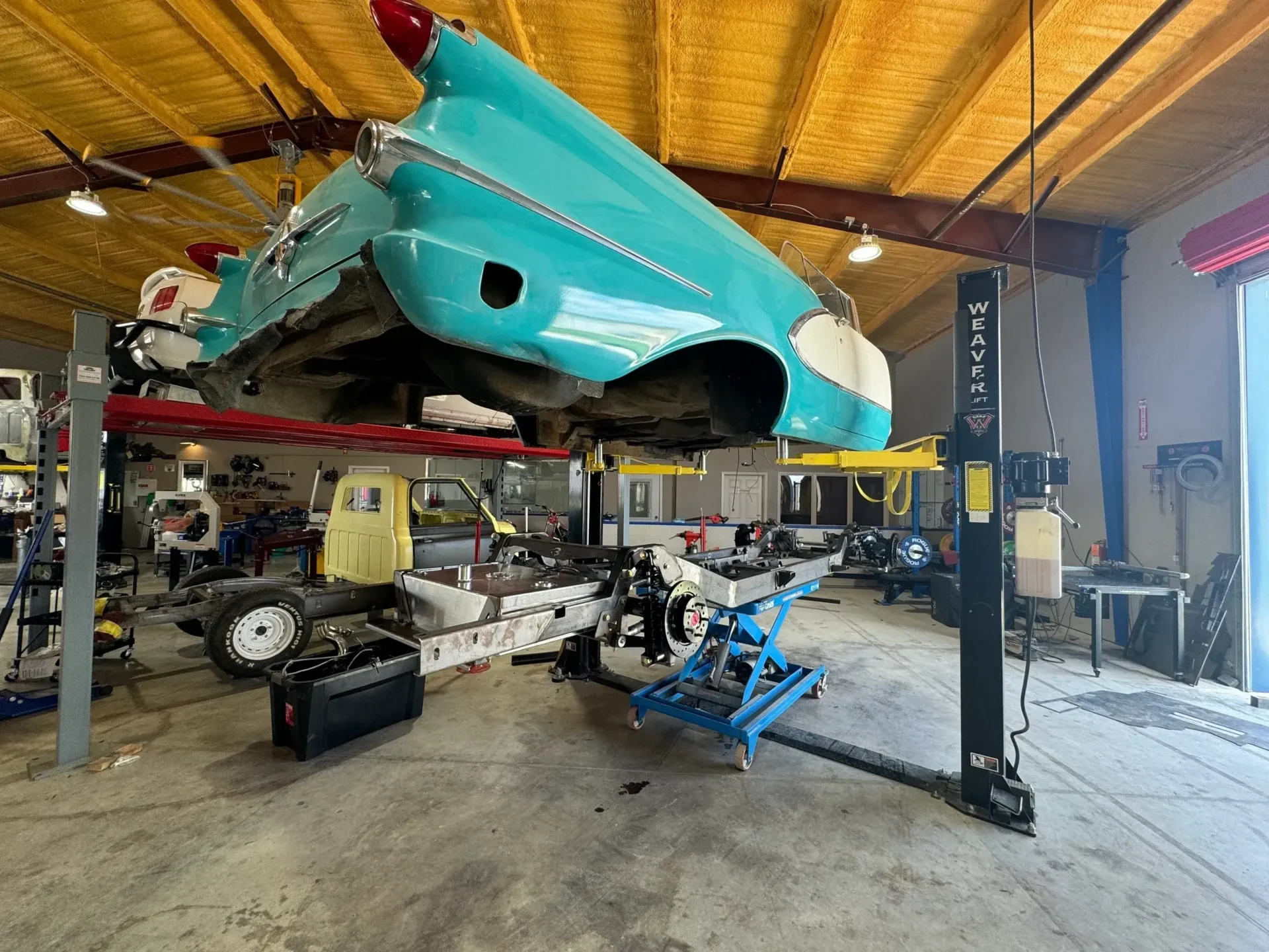 A car is being lifted up in the garage.