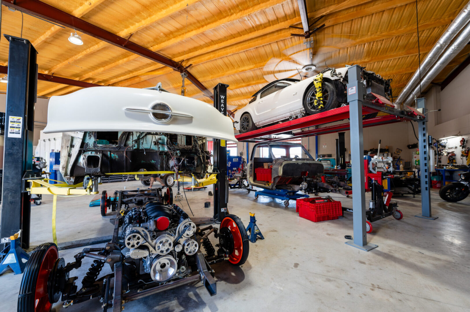 A garage with cars and other vehicles in it.