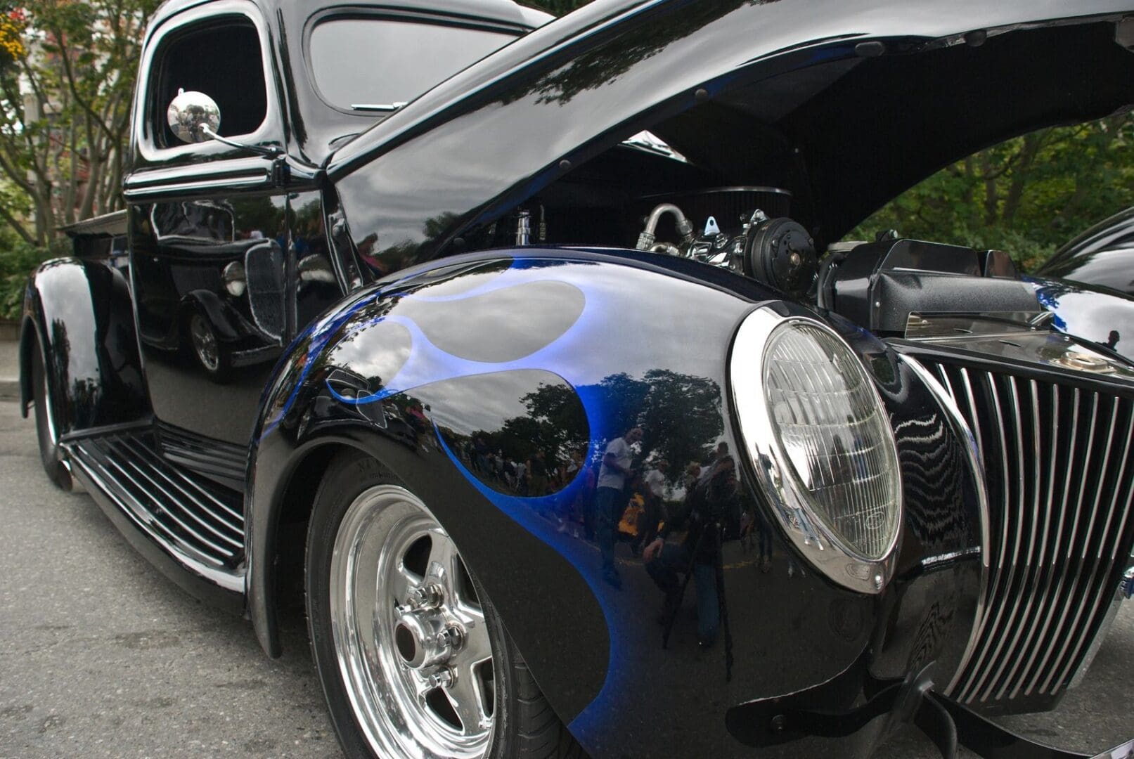 A black car with blue flames on it's hood.